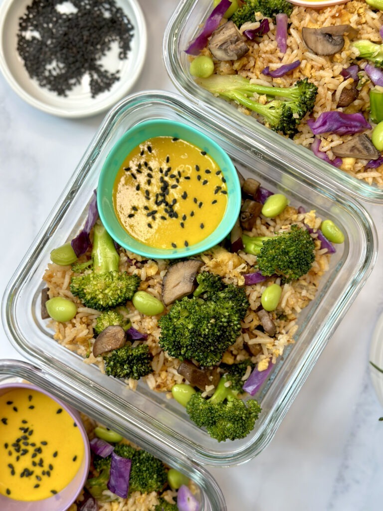 Close up of meal prep container with veggie fried rice and a little container on the side with the miso turmeric dressing. 