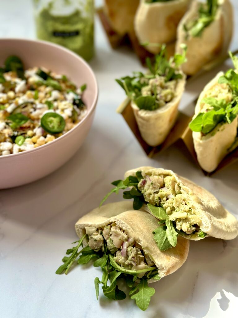 white bean and kale stuffed pitas with zucchini and corn salad on side.