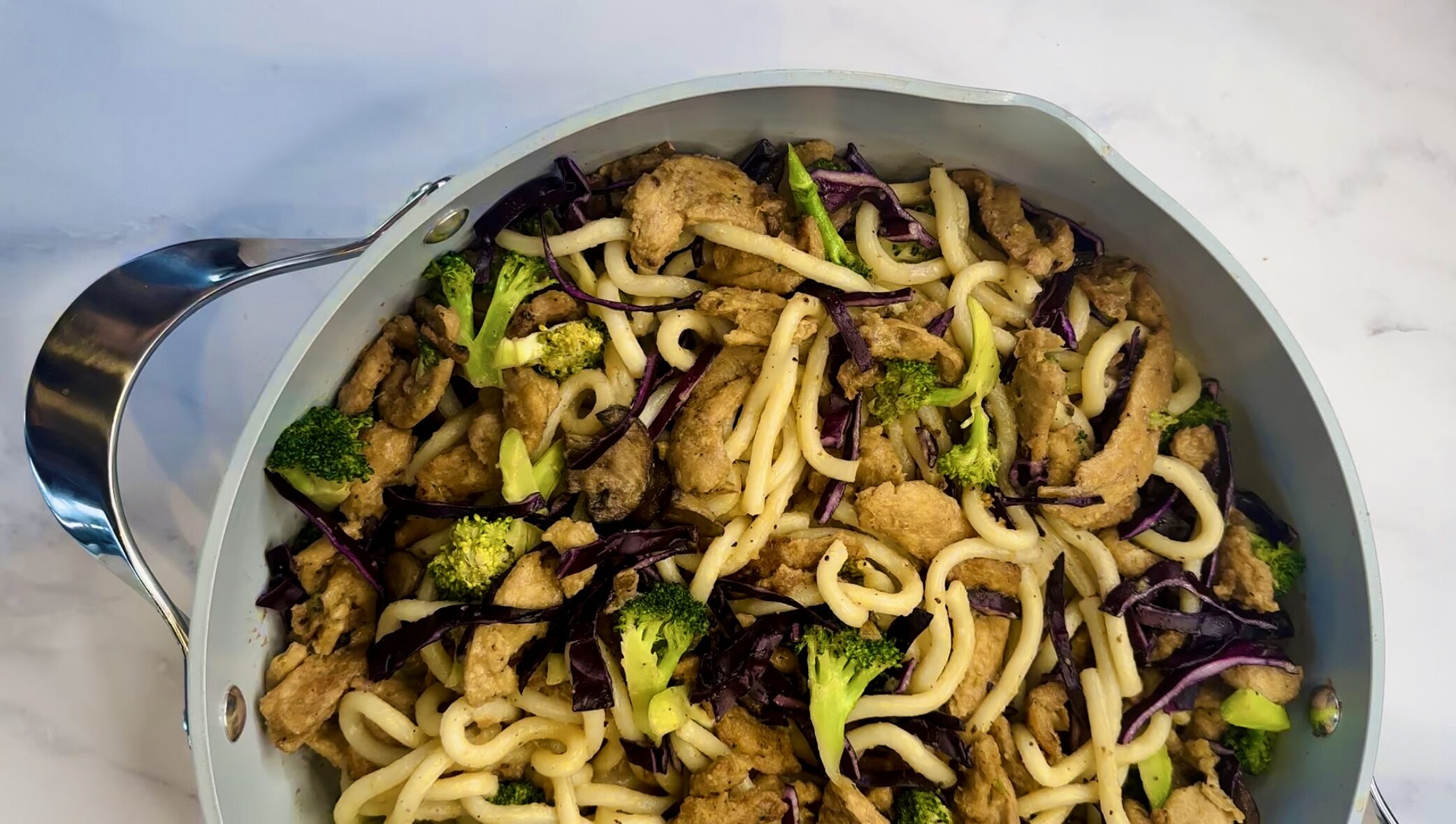 Frying pan with vegan beef and broccoli udon noodles