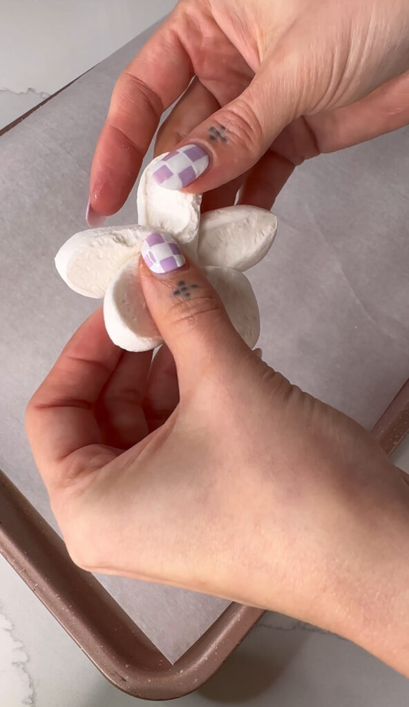 picture of hands repositioning marshmallow slices to make flower petals