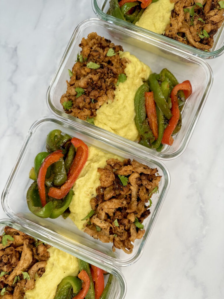 meal prep containers with peppers, cajun soy curls, jalapeno-corn mash