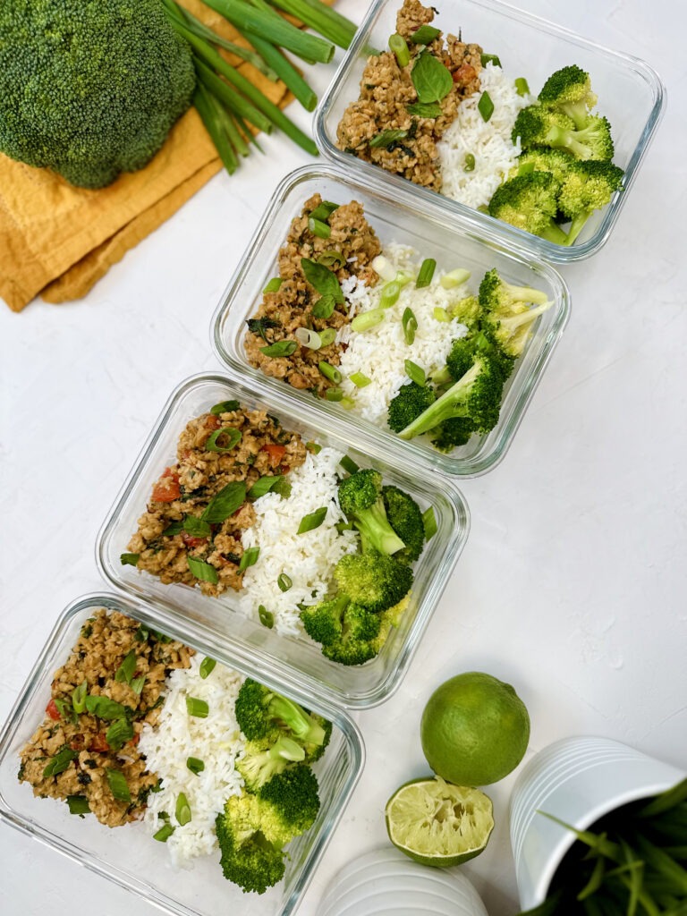 Thai Basil Tempeh Meal Prep: containers with basmati rice, steamed broccoli, thai basil tempeh, green onion, and red peppers.