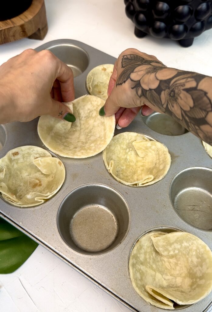 Tortilla circles folded into muffin tins
