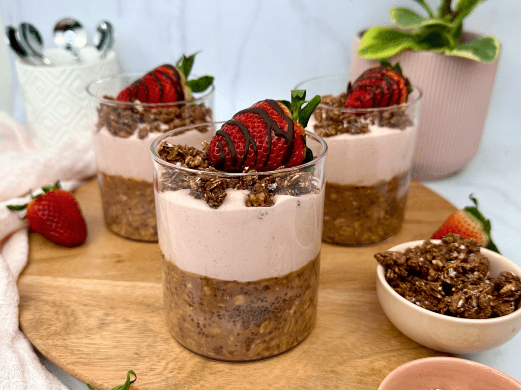 Jars of Chocolate Strawberry breakfast preps, with chocolate oats on the bottom, and strawberry yogurt on top.