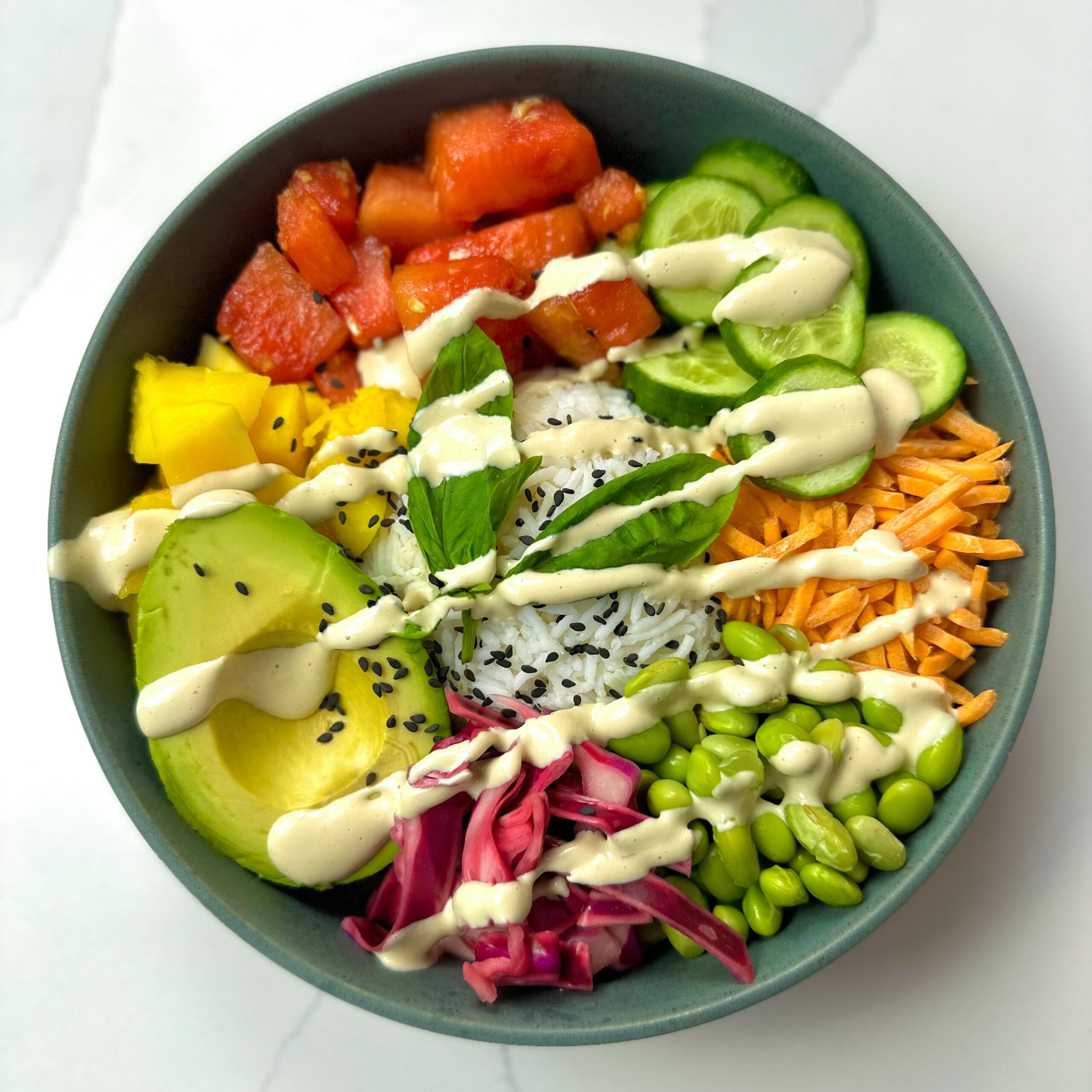 Vegan poke bowl with tahini dressing drizzled on top