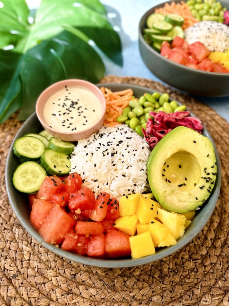 Vegan Poke Bowl with watermelon, mango, rice, avocado, cabbage, edamame, carrots, cucumber and tahini dressing 