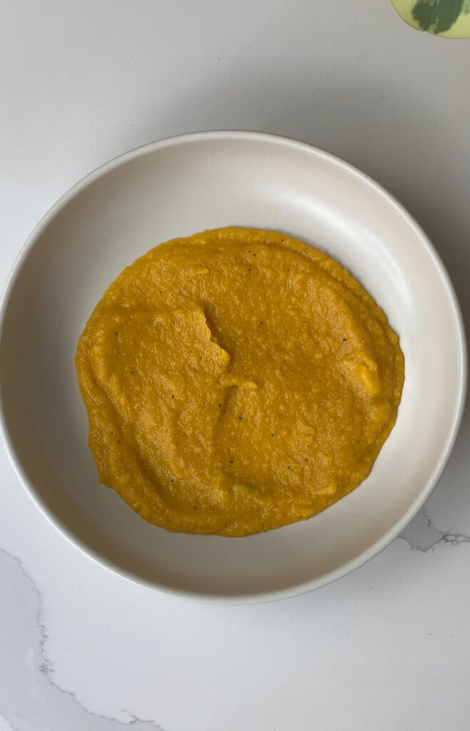 a pasta bowl with a layer of miso butternut squash spread out as a base