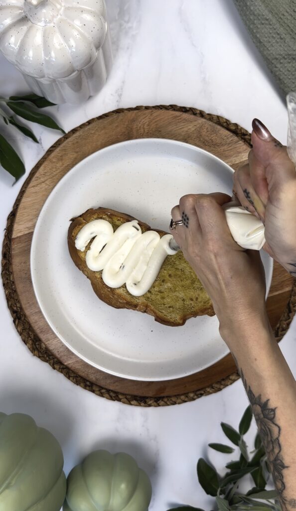 sourdough toast with cream cheese being piped out into a squiggle 