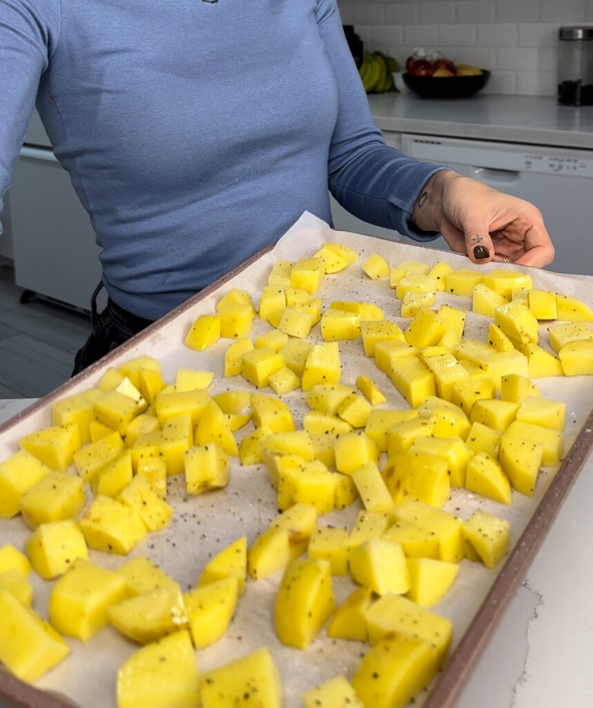 potatoes on a baking sheet with salt and pepepr