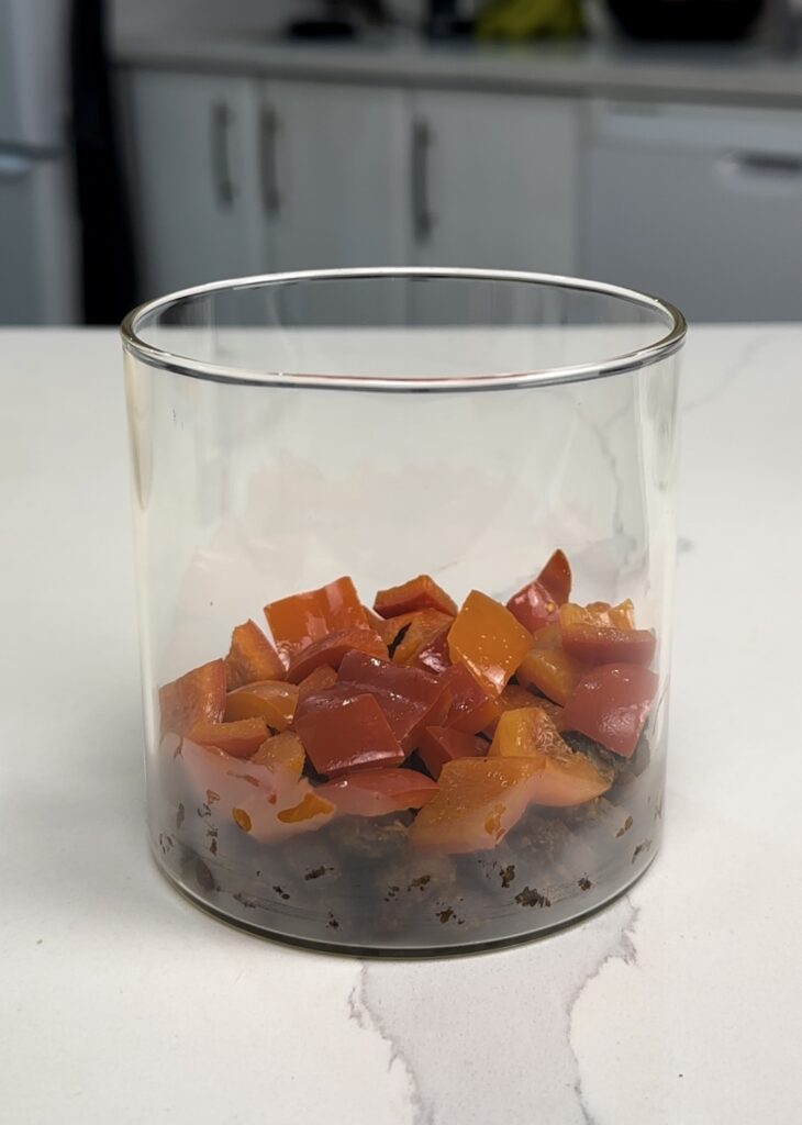 red peppers layered on top of black beans for breakfast jar.