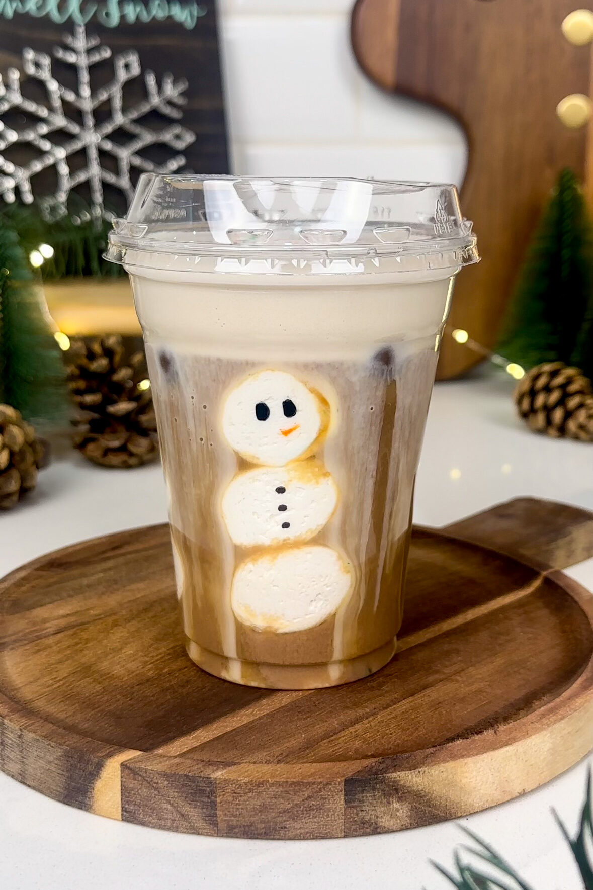 vegan peppermint mocha latte - photo of coffee in plastic cup with marshmallow slices making a snowman on the inside of the cup