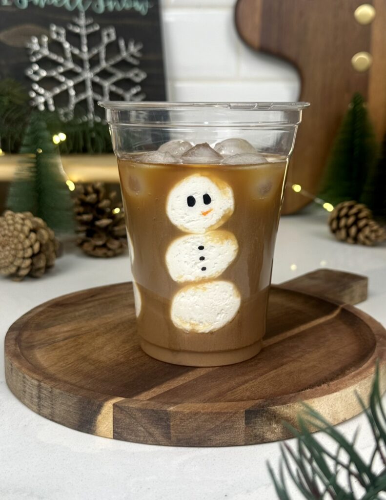 a vegan peppermint mocha - A cup of coffee with peppermint syrup and chocolate milk with a snowman made out of marshmallows