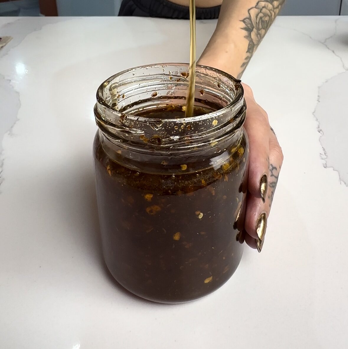 vegan hot and honey sauce drizzled into a mason jar