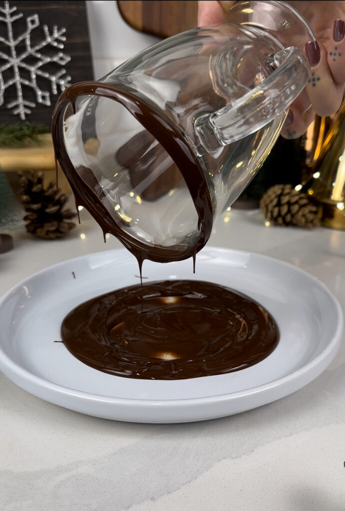 the rim of a mug being dipped in a plate of melted chocolate 