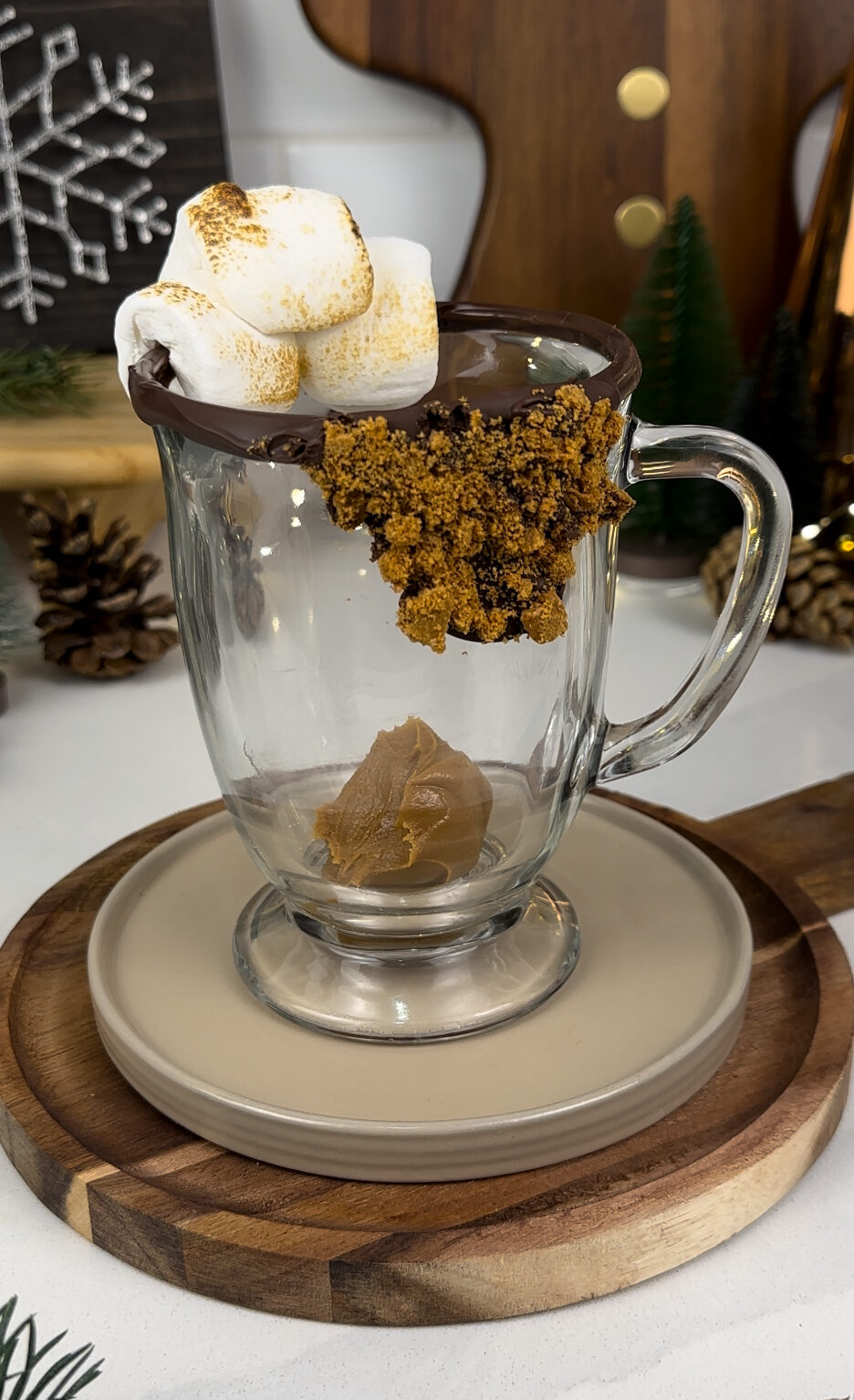 Mug with chocolate and toasted marshmallow rim and a dollop of cookie butter.