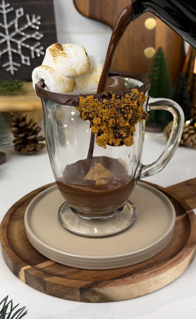 adding hot chocolate to a mug with a dollop of cookie butter.