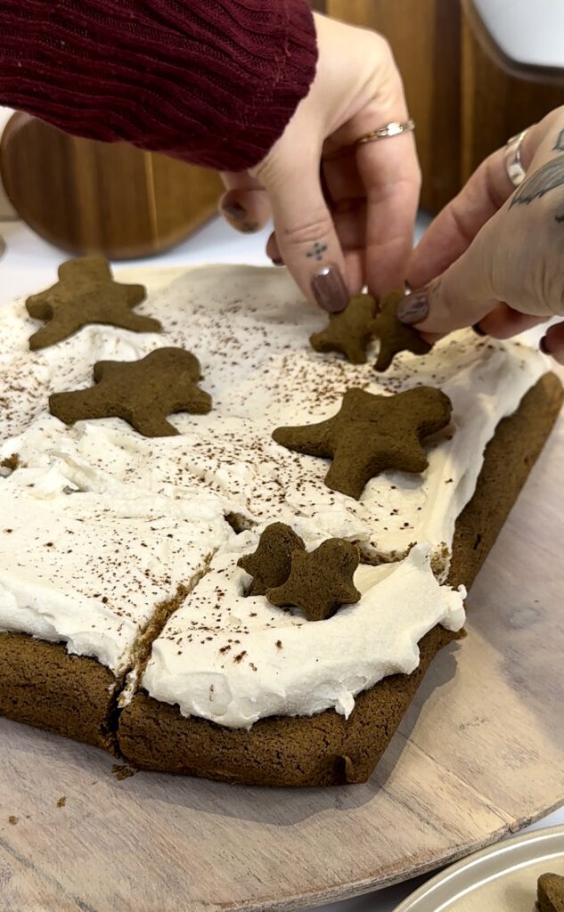 adding gingerbread cookies om top of icing as a topper for the blondies