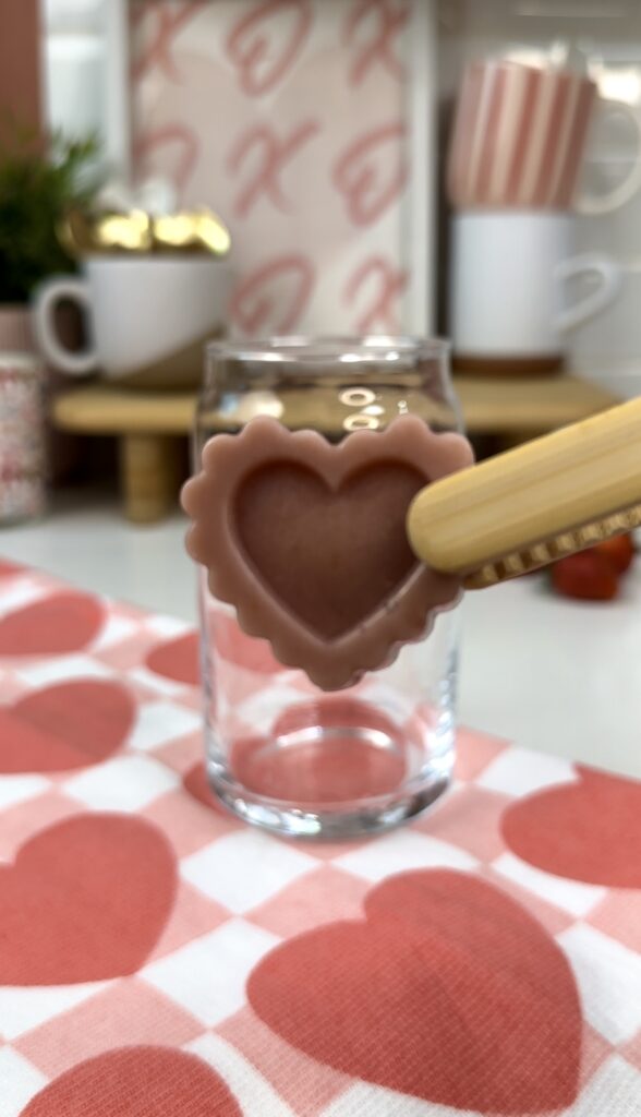 holding a non-dairy strawberry milk heart ice cube