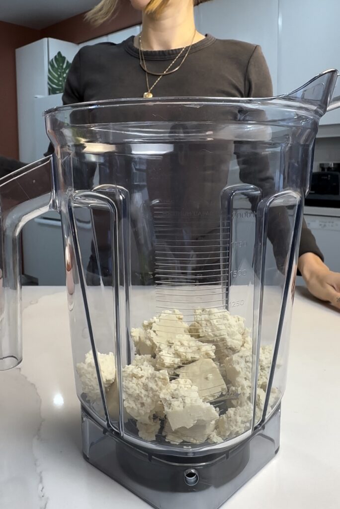 adding tofu to the blender container