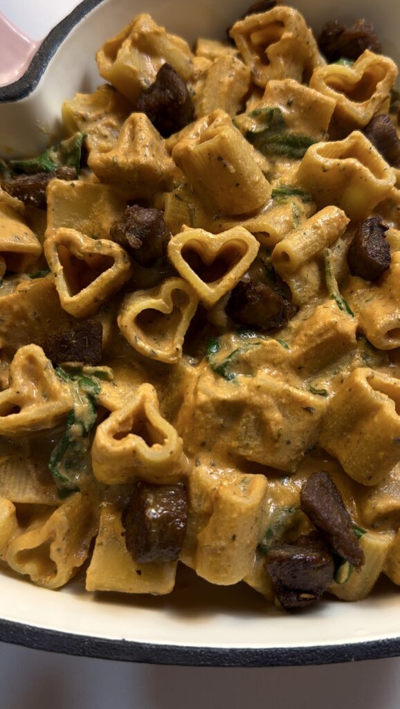 Pink cast iron pan with heart-shaped high-protein vegan rose pasta