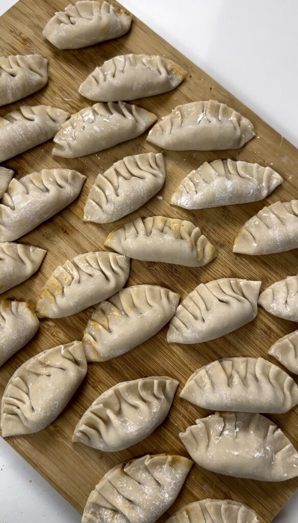 wooden cutting board with fresh dumplings 