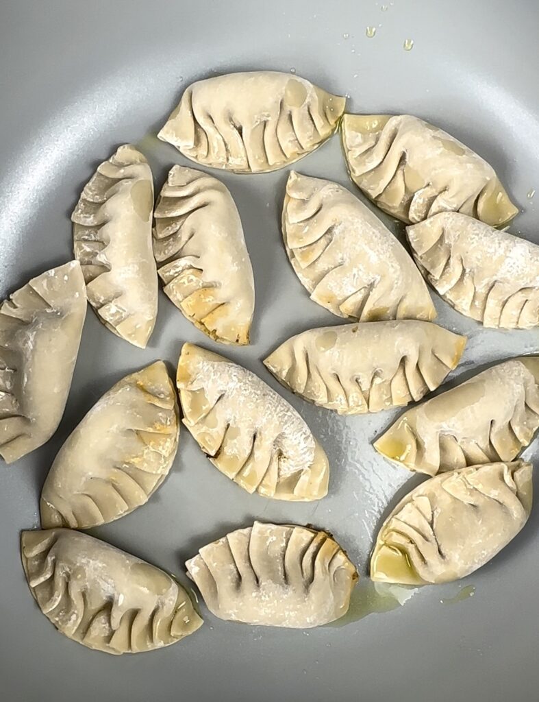 pan with tofu-mushroom dumplings frying