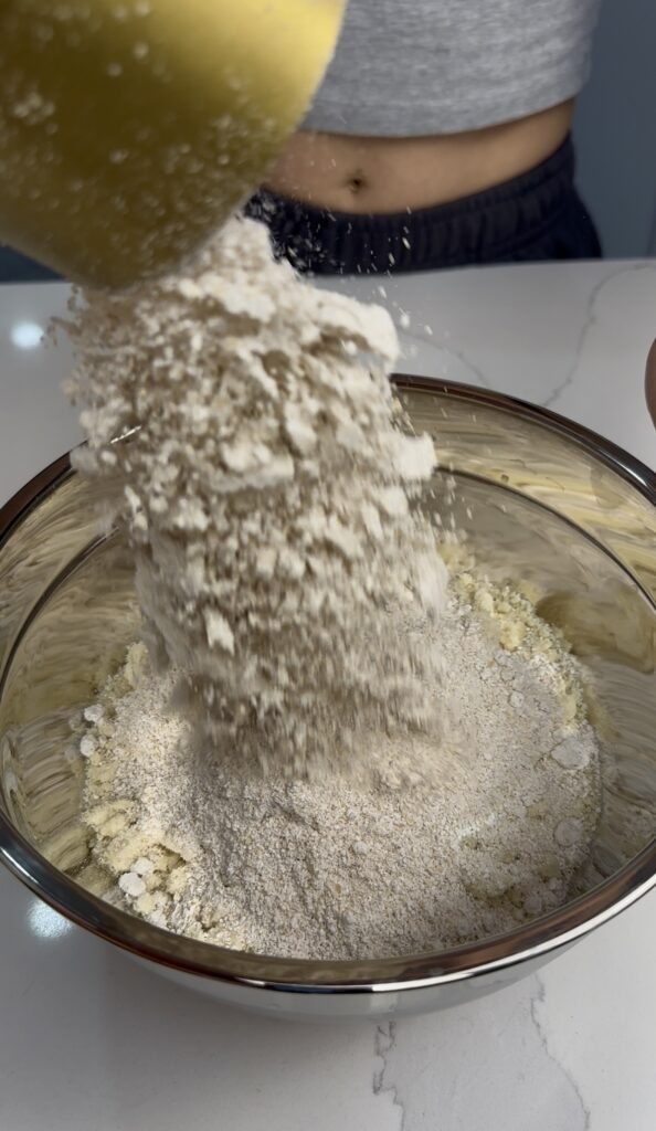 adding oat flour to the almond flour mixture.