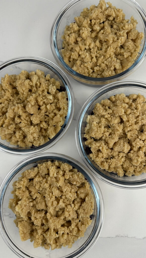 the shortcake crumble added to the meal prep containers pre-oven