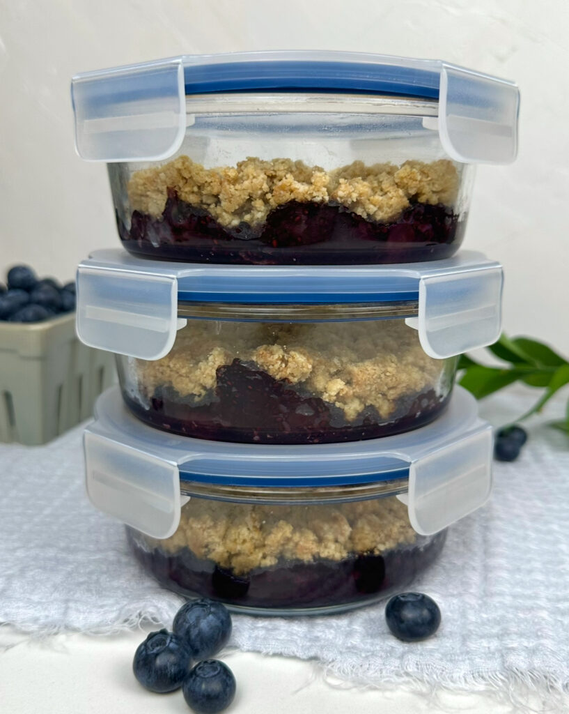 three meal prep containers with blueberry shortcake in them