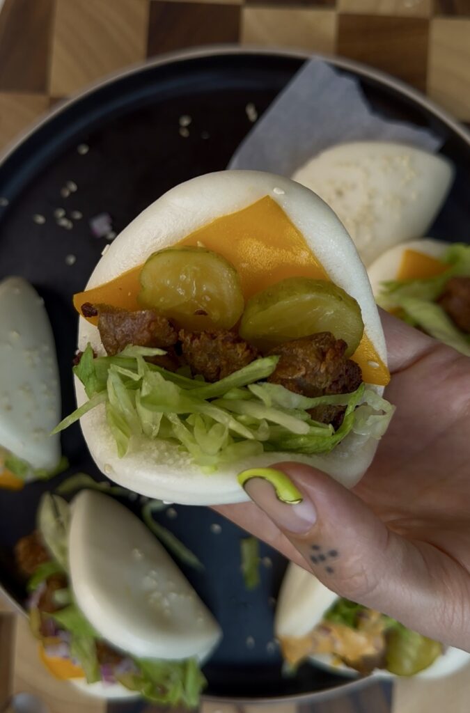 fluffy bao with cheddar cheese, beyond beef, lettuce, and pickles