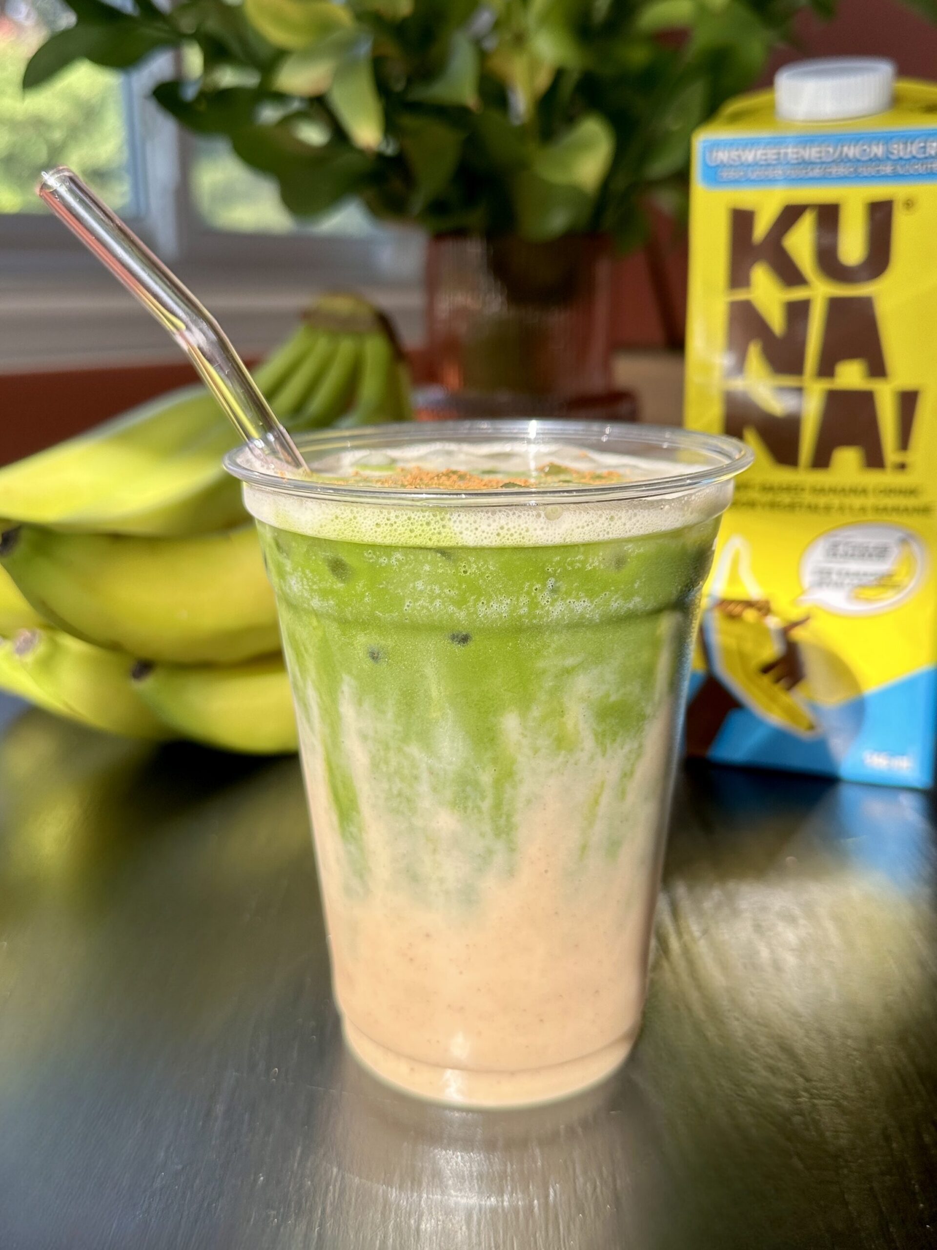 banana bread iced matcha latte with layer of banana bread milk and matcha floating on top