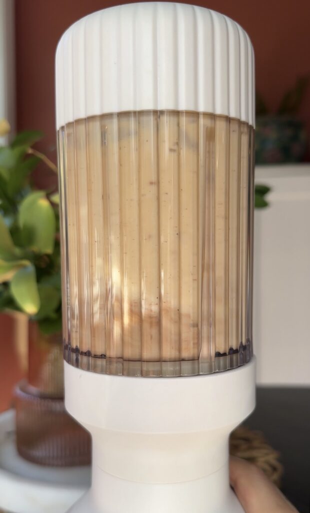 banana milk, a banana, cinnamon, nutmeg and vanilla coffee creamer in a blender