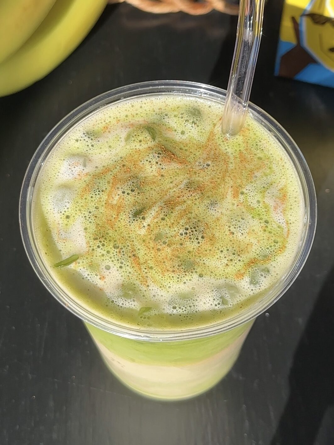 Overhead shot of iced banana bread matcha with cinnamon sprinkled on top