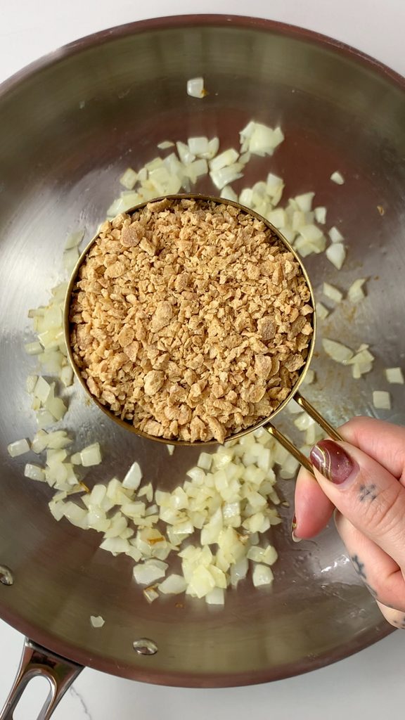 Adding dry TVP to sautéed onions.