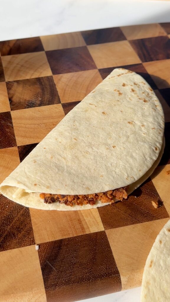 Fold the tacos in half and place on baking tray