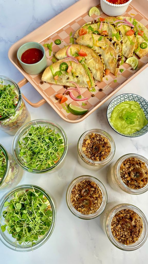 Overhead view of banana bread over night oats, harvest salad jar, and black bean & TVP tacos meal prep.