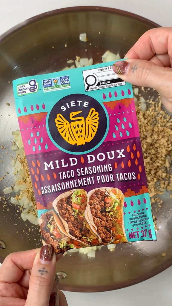 Adding Siete Mild Taco Seasoning to pan