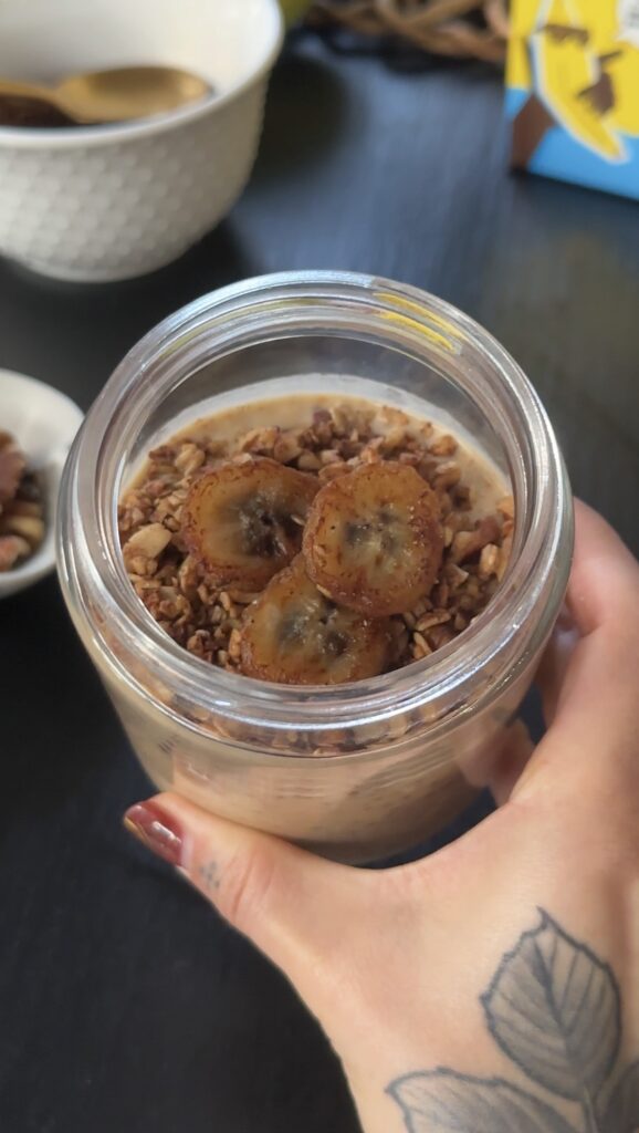 Overhead shot of banana bread over overnight oats with oat crumble and banana slices on top.